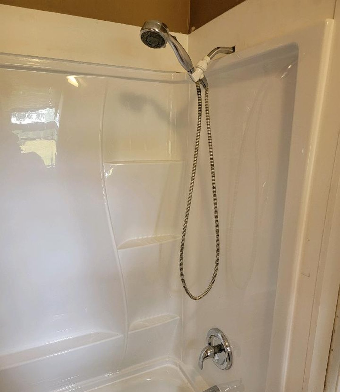 A white tub and shower surround